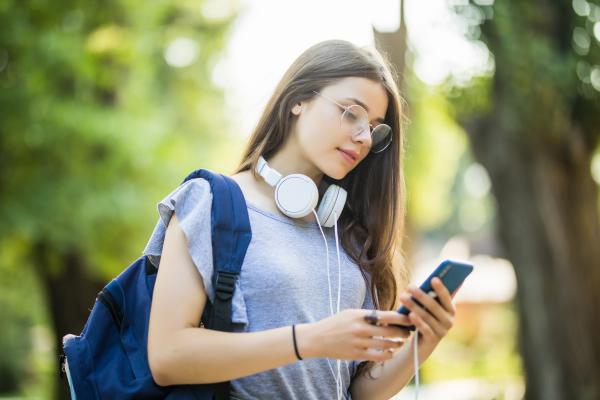 Photo of a female student logging community service hours on her mobile phone using Track it Forward