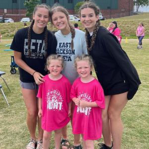 Photo of three female Beta Club students with two young girls at a community service event.