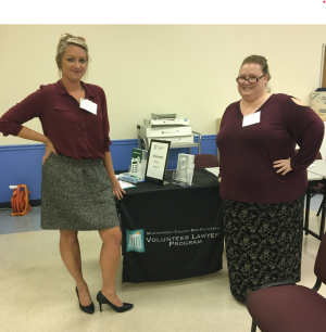 Two students standing in front of a tabletop booth at an event