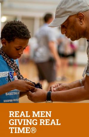 Photo of man helping young boy put on a lanyard. Photo tagline says: 