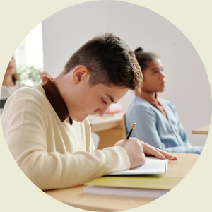 Image of a young boy taking notes in class