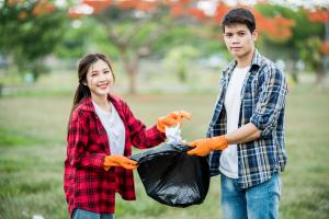 Two students volunteering to clean up a park